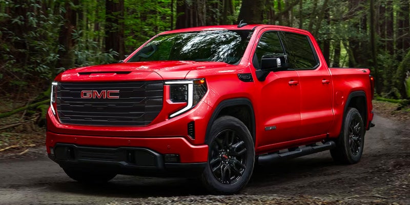 red gmc sierra running in jungle