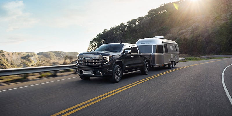 gray gmc sierra runing with towing at back