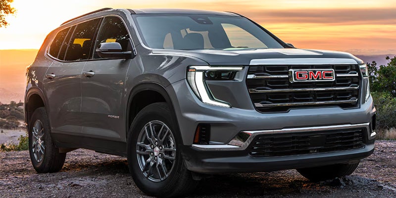 Front three-quarter view of the 2026 GMC Acadia highlighting its signature GMC grille and LED headlights