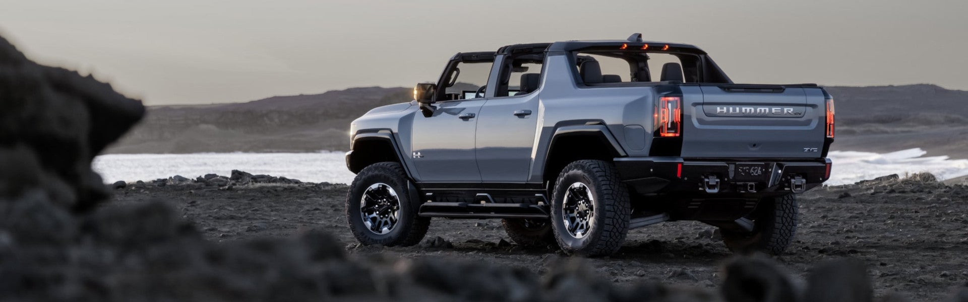 Gray hummer standing beside river