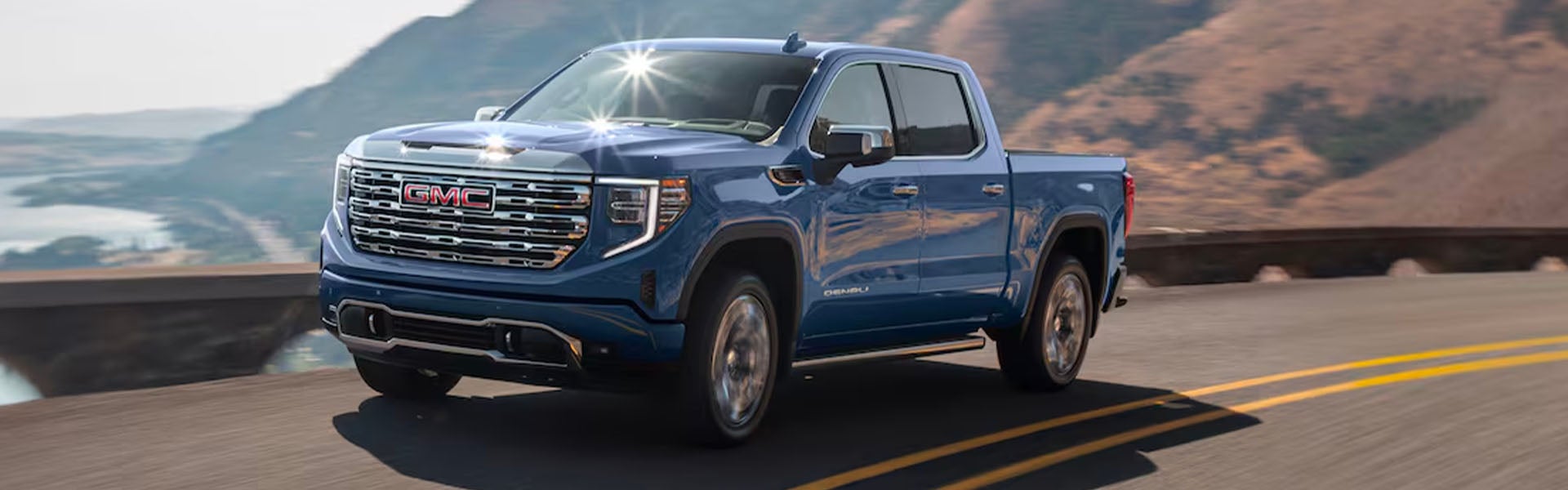 Blue GMC sierra running on road