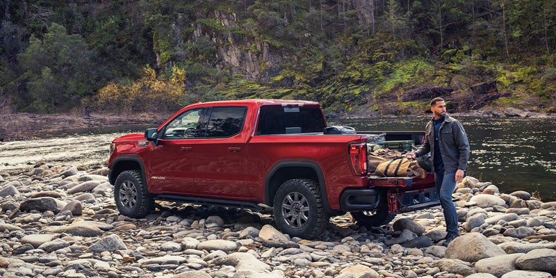 2026 GMC Sierra 1500 AT4 crossing rocky terrain demonstrating off-road capability